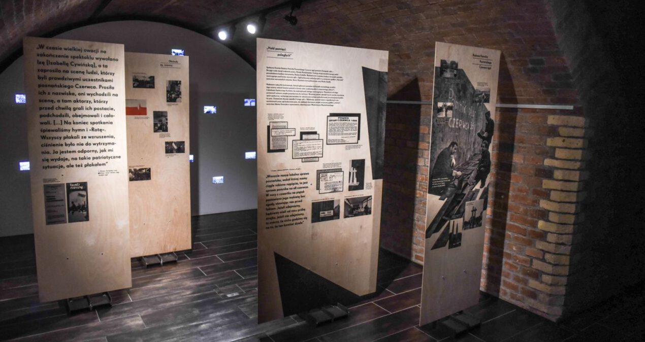 Drewniane plansze z treścią wystawy ustawione w przestrzeni sali wystawowej