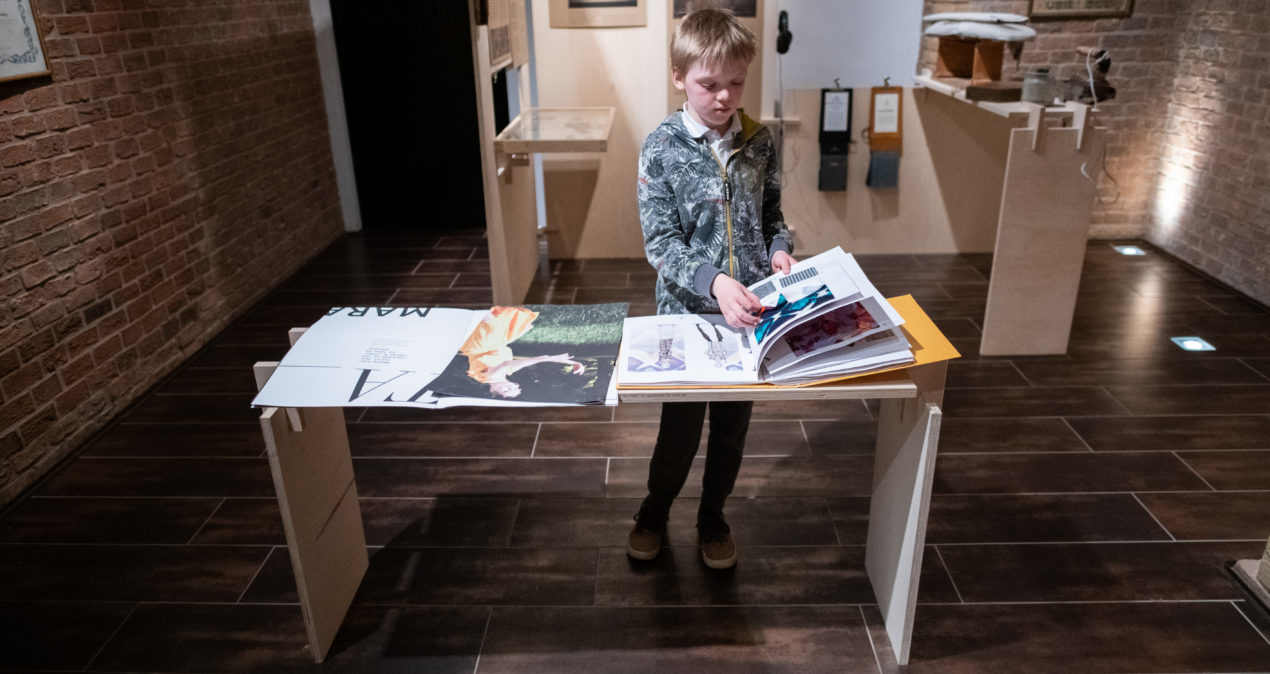 Chłopiec ogląda katalog materiałów na jednym ze stanowisk na wystawie/