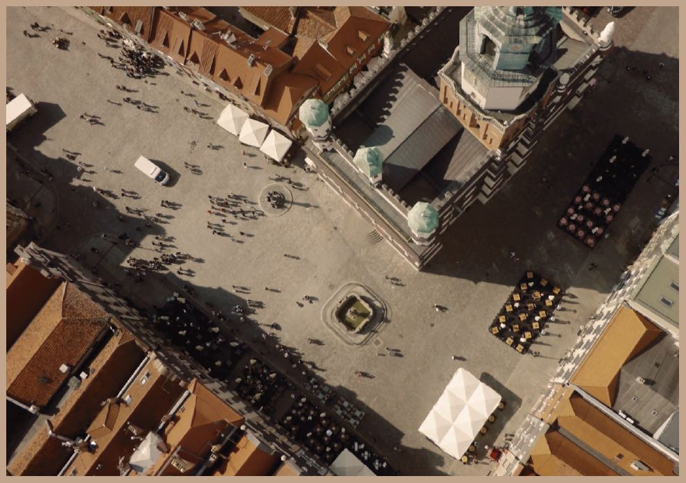 Widok na rynek w Poznaniu z góry. Widoczny dach ratusza z wieżą a przed nim plac.