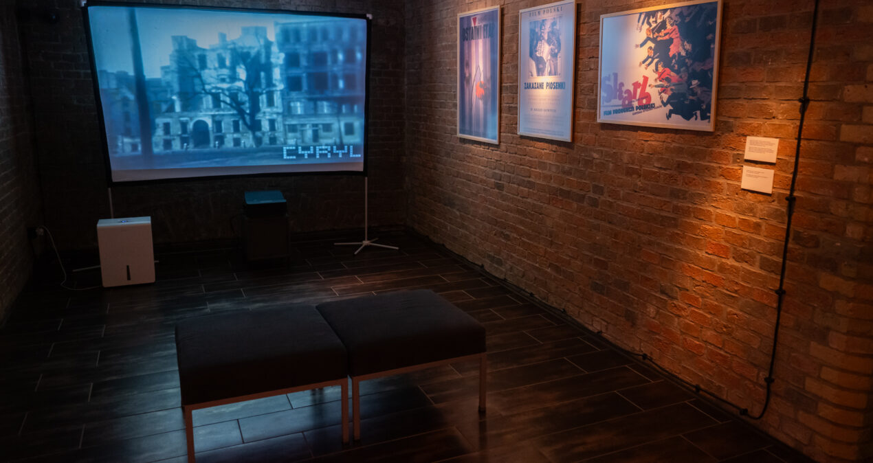 Sala na wystawie, w której znajduje się projekcja czarno-białego filmu