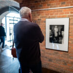 Przestrzeń galerii. Mężczyzna ogląda fotografię artysty w pracowni